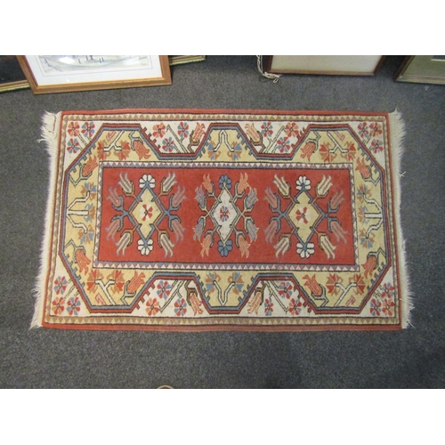 1043 - A terracotta ground rug with multiple borders and central panel, 132cm x 86cm