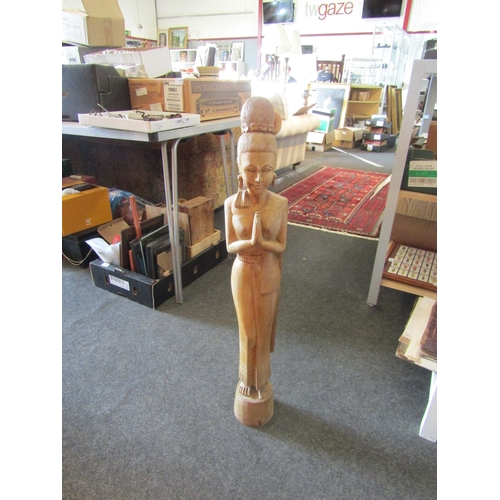 1460 - A modern carved wooden figure of a Thai female with hands in prayer stance, 88cm tall