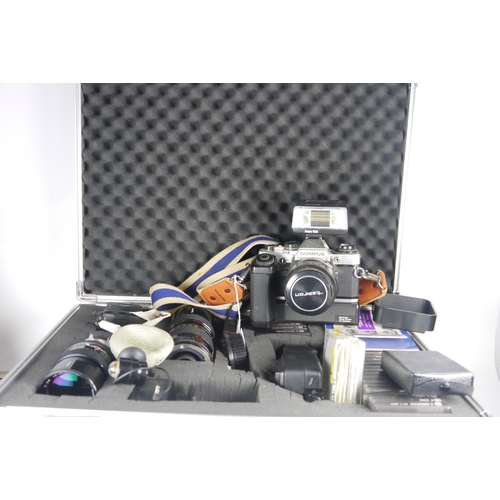 6092 - A cased Olympus OM10 SLR 35mm film camera w/ multiple Tamron lenses & accessories