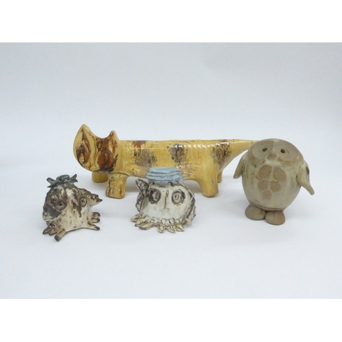 7071 - A Studio pottery cat, indistinctly signed underneath and three studio pottery owls, tallest 11cm