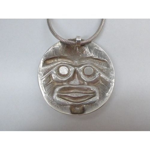 7355 - A modernistic mask pendant, signed 'R.Smith' to reverse, with abalone shell eyes and teeth, 6.3cm di... 