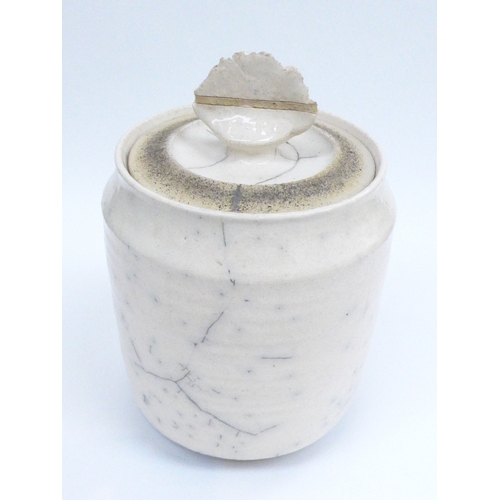 7078 - A large Raku pottery lidded canister, cream white glaze. Indistinct signature to base. 28cm high