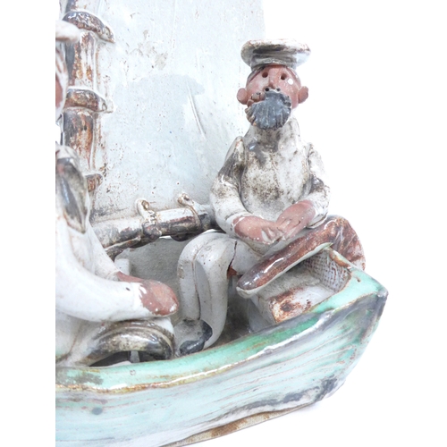 7081 - Two Seven Springs pottery figures in a boat and a cricketer. Labelled. Tallest 21cm