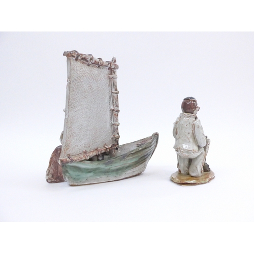 7081 - Two Seven Springs pottery figures in a boat and a cricketer. Labelled. Tallest 21cm