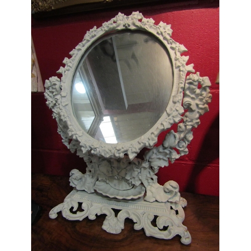 4132 - A cast metal toilet mirror embossed with leaves and flowers, shell dish to base, 48cm tall