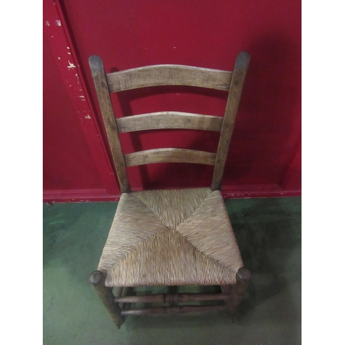 4006 - An early 20th Century ladder-back rocking chair with rush seat