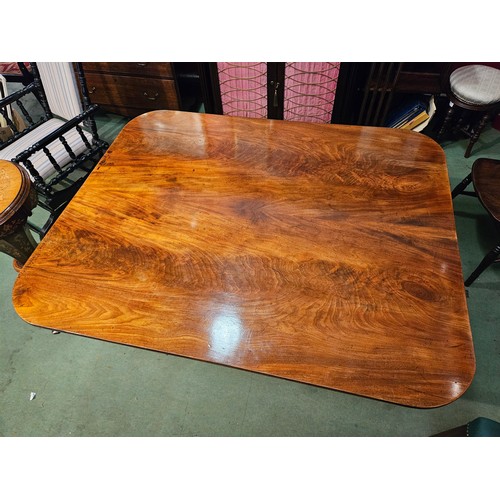 4063 - A circa 1860 flame mahogany tilt-top table on a turned column and outswept legs terminating onto orn... 