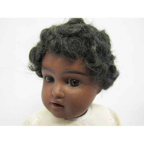 9257 - An early 20th Century German bisque head black girl doll with black wig, fixed brown glass eyes, pai... 