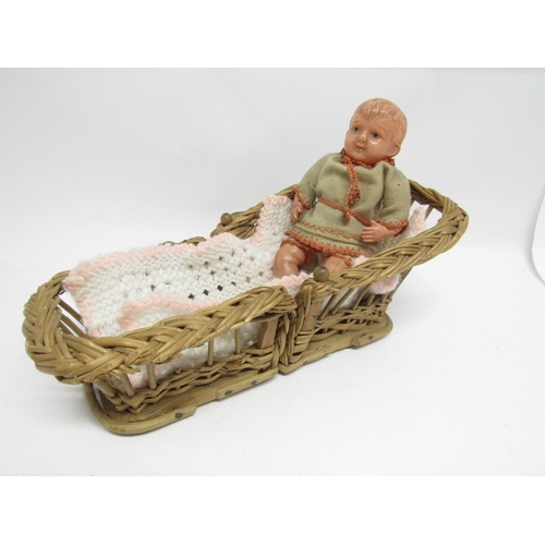 9228 - A vintage Japanese celluloid boy doll, 17.5cm tall, in folding wicker cot / chair