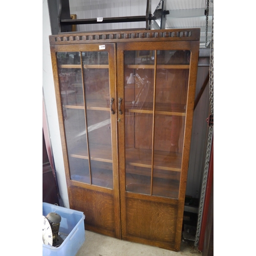 2108 - A 1930's oak glazed two door cabinet, 2 paynes cracked