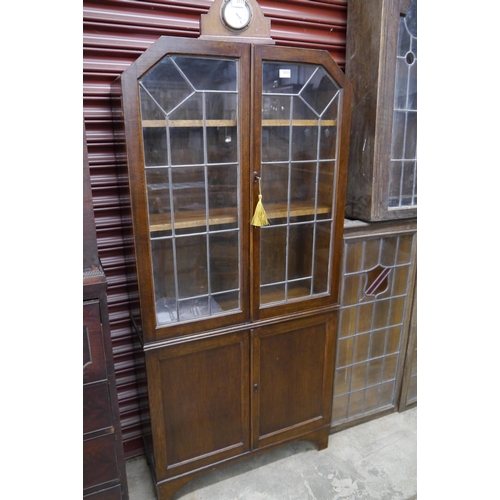 2111 - A 1920's oak lead glazed bookcase over cupboard