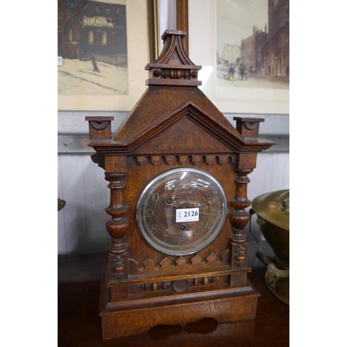 2126 - An oak mantel clock of architectural form numerated chaptering (finials missing)