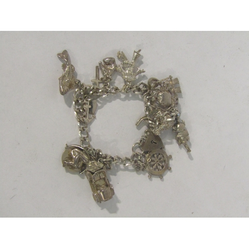 4395 - A charm bracelet with white metal and silver charms with further charms on a separate chain includin... 