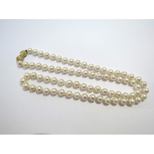 9373 - A single strand pearl necklace, 6mm diameter with a diamond set 9ct gold bow clasp, 28cm long, in Di... 