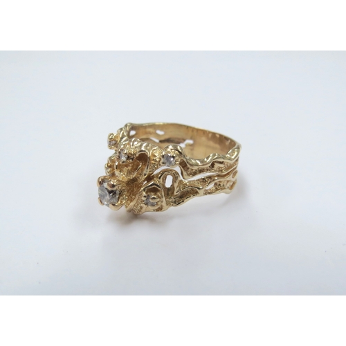 9024 - An unmarked gold ring of naturalistic form set with six diamonds, the larger in claw mount. Size N, ... 