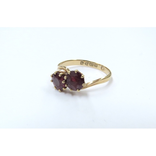 9073 - An 18ct gold Chester hallmarked crossover garnet ring. Size P, 2.7g