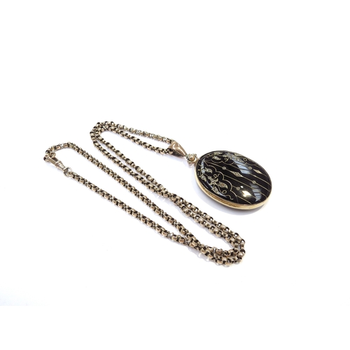 9207 - A late Victorian gold and black enamelled oval pendant set with seed pearls and gold line decoration... 