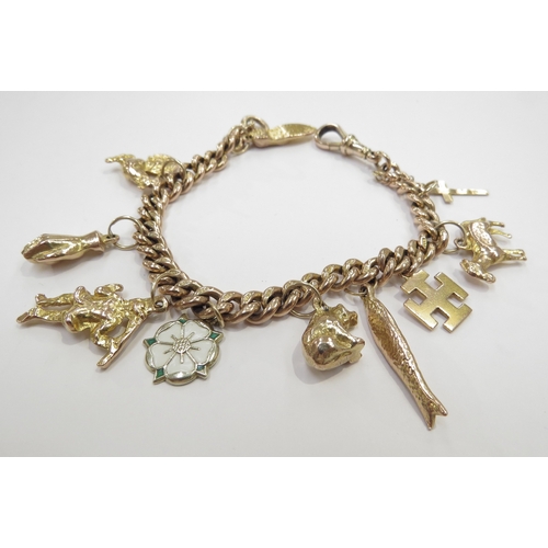 9071 - A 9ct gold charm bracelet, each link stamped 9c 375, 18cm long, hung with various charms some 9ct, 3... 