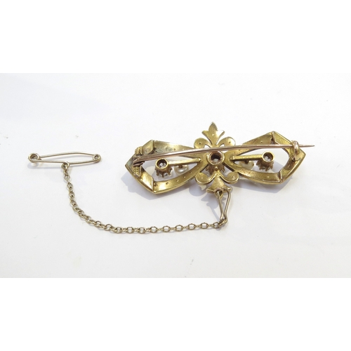 9206 - An unmarked gold brooch with centre diamond 0.40ct approx flanked by 0.25ct diamonds in a split pear... 