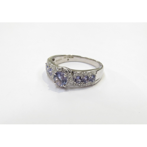 9416 - An 18ct white gold Tanzanite and diamond cluster ring. Size R/S, with Anchor Cert certificate, 4.5g