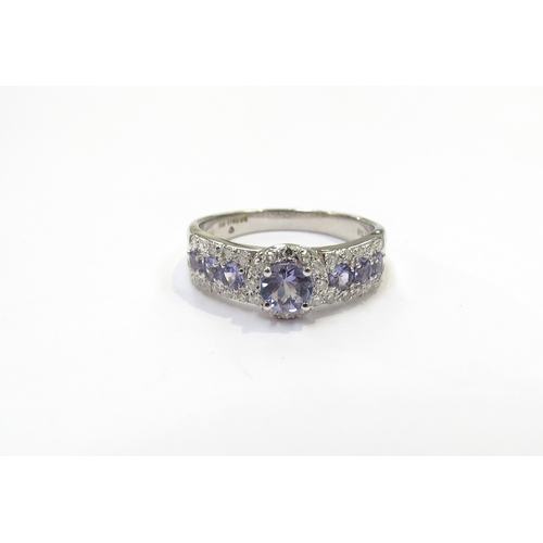 9416 - An 18ct white gold Tanzanite and diamond cluster ring. Size R/S, with Anchor Cert certificate, 4.5g