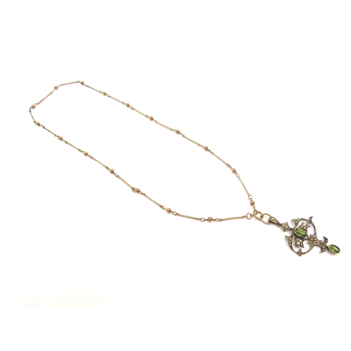 9327 - A 9ct gold long bar and ball link chain, 44cm long hung with an Edwardian seed pearl and peridot pen... 