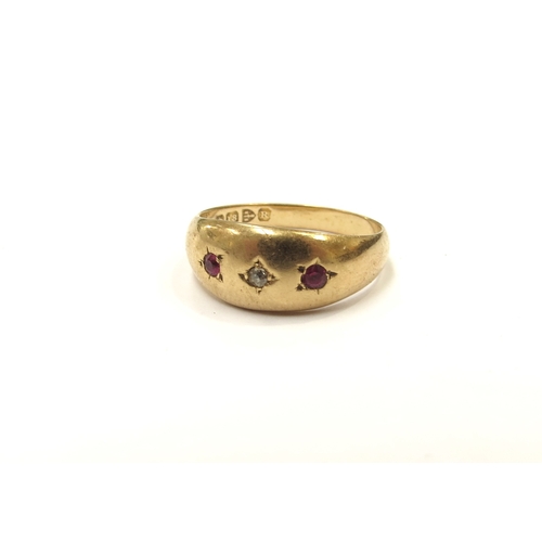 9293 - An 18ct gold gypsy ring set with central diamond chip flanked by small rubies. Size P, 2.2g