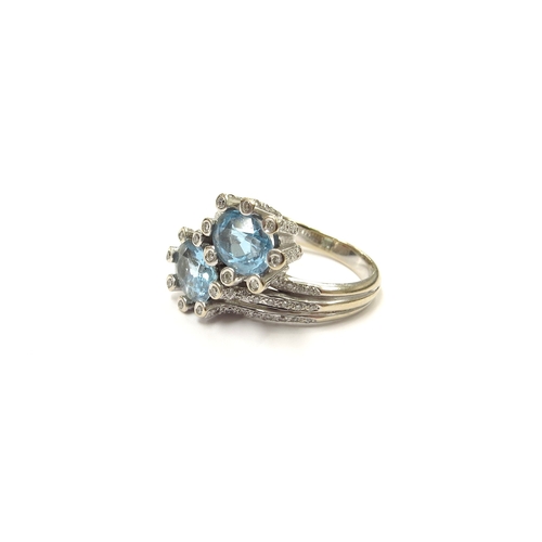 9060 - An 18ct white gold topaz and diamond ring, the two oval topaz framed by diamonds in crossover settin... 