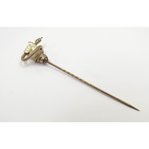 9094 - A gold stick pin with mother-of-pearl hand clenching a snake