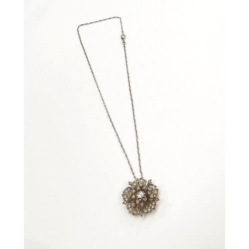 9049 - A diamond set floral pendant, centre diamond 0.30ct approx hung on chain, 9.8g total