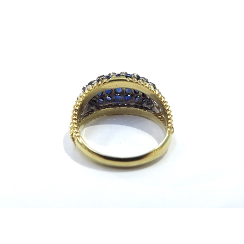 9160 - An 18ct yellow and white gold domed sapphire and diamond studded dress ring, invisible set sapphires... 