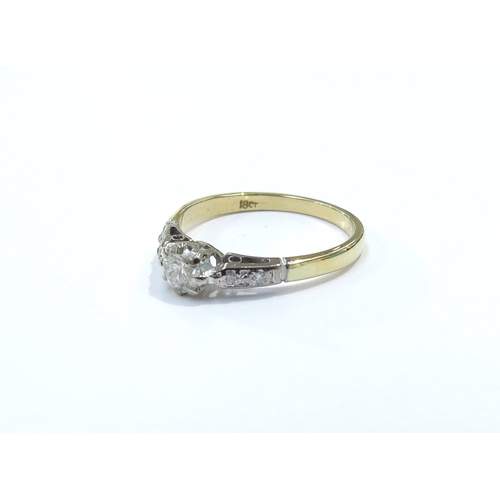 9086 - A diamond solitaire ring with diamond set shoulders, stamped 18ct. Size P/Q, 2.8g