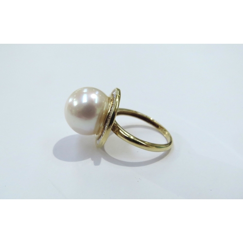 9079 - An 18ct gold Iliana pearl and diamond ring the centre pearl 12cm diameter framed by diamonds. Size M... 