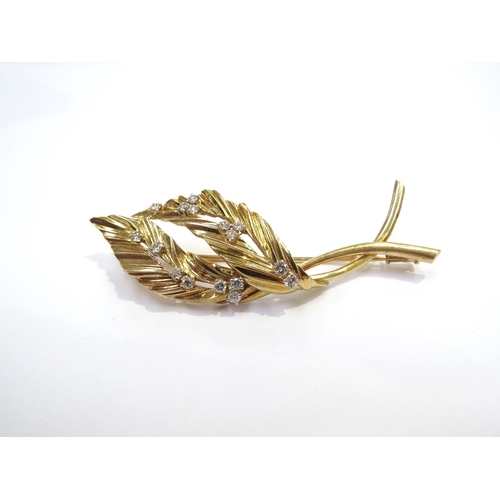 9054 - An 18ct gold leaf form brooch studded with 16 brilliant cut diamonds, 15.8g