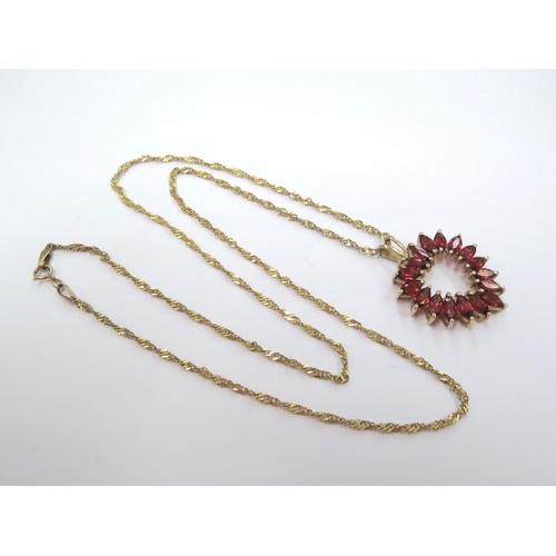 9314 - A 9ct gold chain, 50cm long, hung with a heart shaped pendant with orange/red stones, stamped 375, 5... 