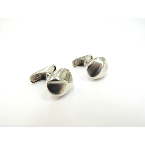 9396 - A pair of Georg Jensen silver cushion shape cufflinks with a curved diagonal ridge on an arched spru... 