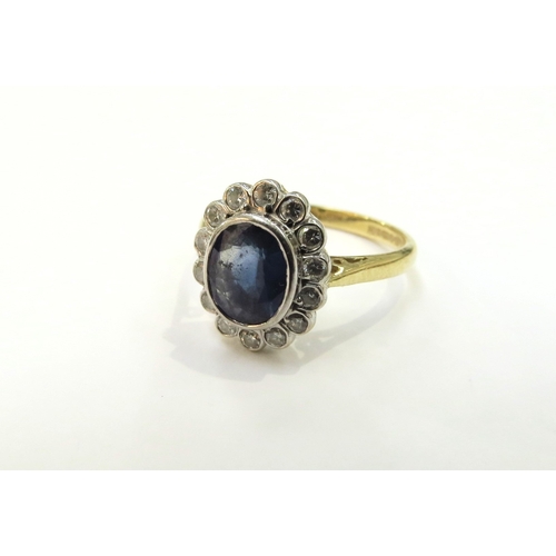 9061 - An 18ct gold sapphire and diamond cluster ring, 7mm x 6mm framed by 14 round cut diamonds. Size K/L,... 