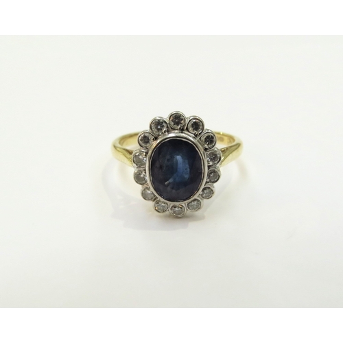 9061 - An 18ct gold sapphire and diamond cluster ring, 7mm x 6mm framed by 14 round cut diamonds. Size K/L,... 