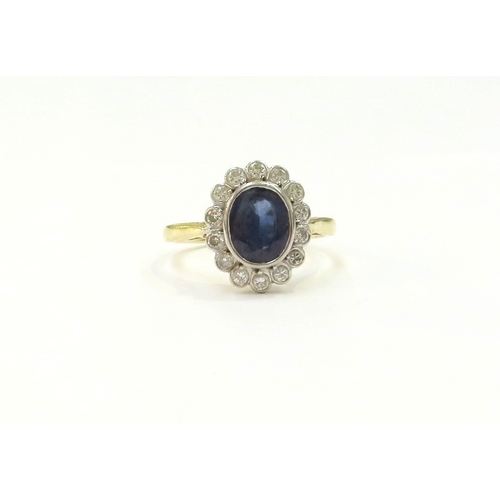 9061 - An 18ct gold sapphire and diamond cluster ring, 7mm x 6mm framed by 14 round cut diamonds. Size K/L,... 