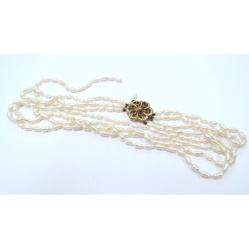 9057 - A four strand freshwater pearl necklace (one end detached) with an 18ct gold clasp set with sapphire... 