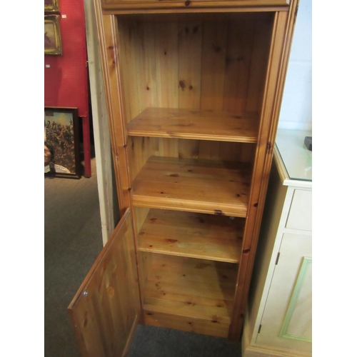 1021 - A Victorian style natural pine narrow cabinet, the single drawer over an open shelf and single door ... 