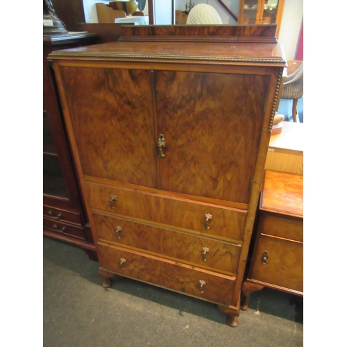 1103 - A 1930's walnut drinks cabinet, two doors over three long drawers, squashed bun feet, 132cm tall x 7... 