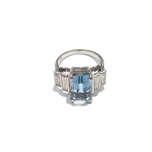 9418 - An 18ct white gold ring, central emerald cut aquamarine 4ct approx flanked by two graduated baguette... 