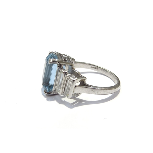 9418 - An 18ct white gold ring, central emerald cut aquamarine 4ct approx flanked by two graduated baguette... 