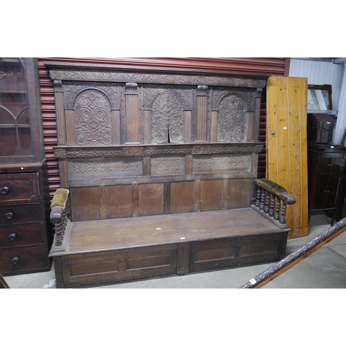 2096 - An 18th Century and later country oak settle of large proportions, carved composite high back