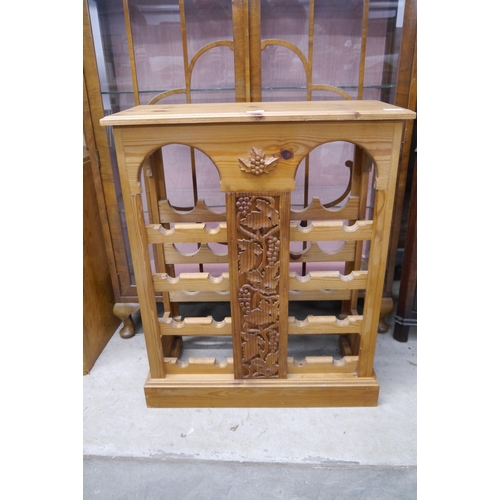 2412 - A country pine wine rack, grape and vine carved detail, plinth base