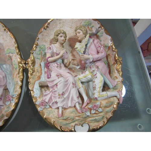 1562 - A pair of Capodimonte ceramic wall plaques depicting courting couples surrounded by Doves and flower... 