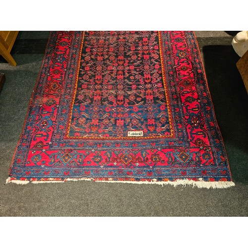 1025A - An Eastern red and blue ground geometric design rug with multiple borders, worn, 270cm x 140cm