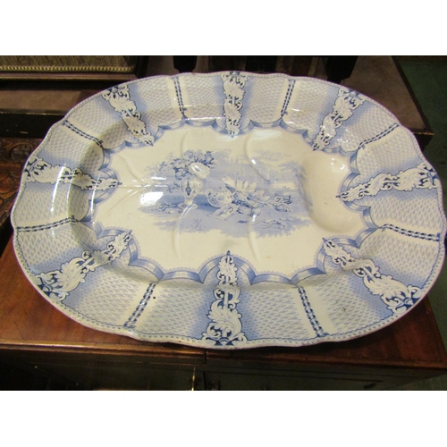 4193 - A 19th Century blue and white printed meat platter with gravy well, centre printed with shell, vase,... 