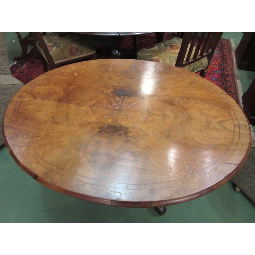 4194 - A circa 1850 inlaid walnut oval tilt-top table over turned columns and central finial on carved acan... 